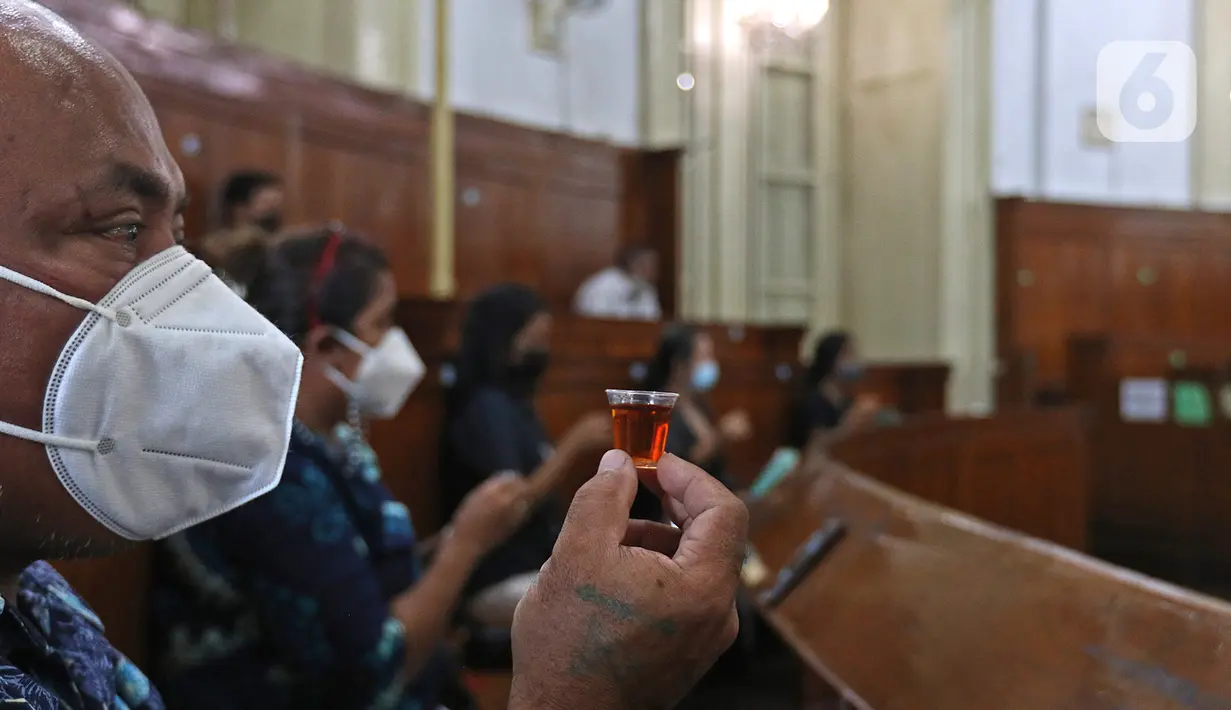 Umat Kristiani melakukan prosesi ibadah misa Jumat Agung pada rangkaian Hari Raya Paskah di Gereja Immanuel, Jakarta, Jumat (2/4/2021). Dalam suasana pandemi, misa Jumat Agung diselenggarakan dengan memberlakukan pembatasan kedatangan jemaat serta secara daring. (Liputan6.com/Herman Zakharia)