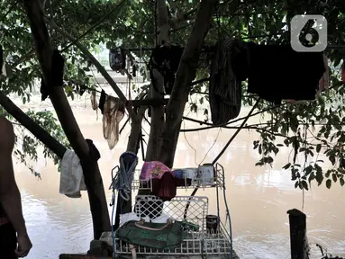 Salah seorang warga berdiri di pinggir bantaran kali usai banjir merendam gubuk miliknya yang berada di pinggir Kanal Banjir Barat (KBB), Jakarta, Rabu (8/1/2020). (merdeka.com/Iqbal S Nugroho)