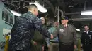 Presiden AS, Donald Trump berjaabat tangan dengan salah satu pasukan saat mengunjungi kapal induk Gerald R. Ford di Newport News, Virginia (2/3). Trump tampak gagah mengenakan jaket panglima tertinggi Navy Seal. (AFP Photo / Saul Loeb)