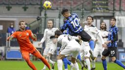 Striker Inter Milan, Lautaro Martinez, melepaskan sundulan ke gawang Spezia pada laga Liga Italia di Stadion Giuseppe Meazza, Minggu (20/12/2020). Inter Milan menang dengan skor 2-1. (AP/Luca Bruno)