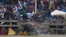 <p>Penonton melarikan diri dari banteng selama Festival Our Lady of the Rosary di Desa Andes Huarina, Bolivia, Senin (3/10/2022). Sekelompok adu banteng amatir melakukan parodi dari adu banteng Spanyol, tetapi tanpa mengorbankan banteng. (AP Photo/Juan Karita)</p>