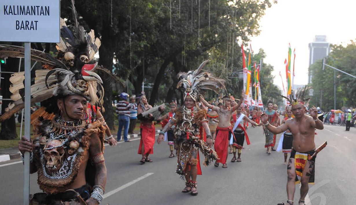 Aksi peserta dari Etnik Dayak selama kegiatan Pawai Seni & Budaya Kreatif 2014 di Jalan Medan Merdeka Barat, Jakarta, Senin (18/8/14). (Liputan6.com/Herman Zakharia)