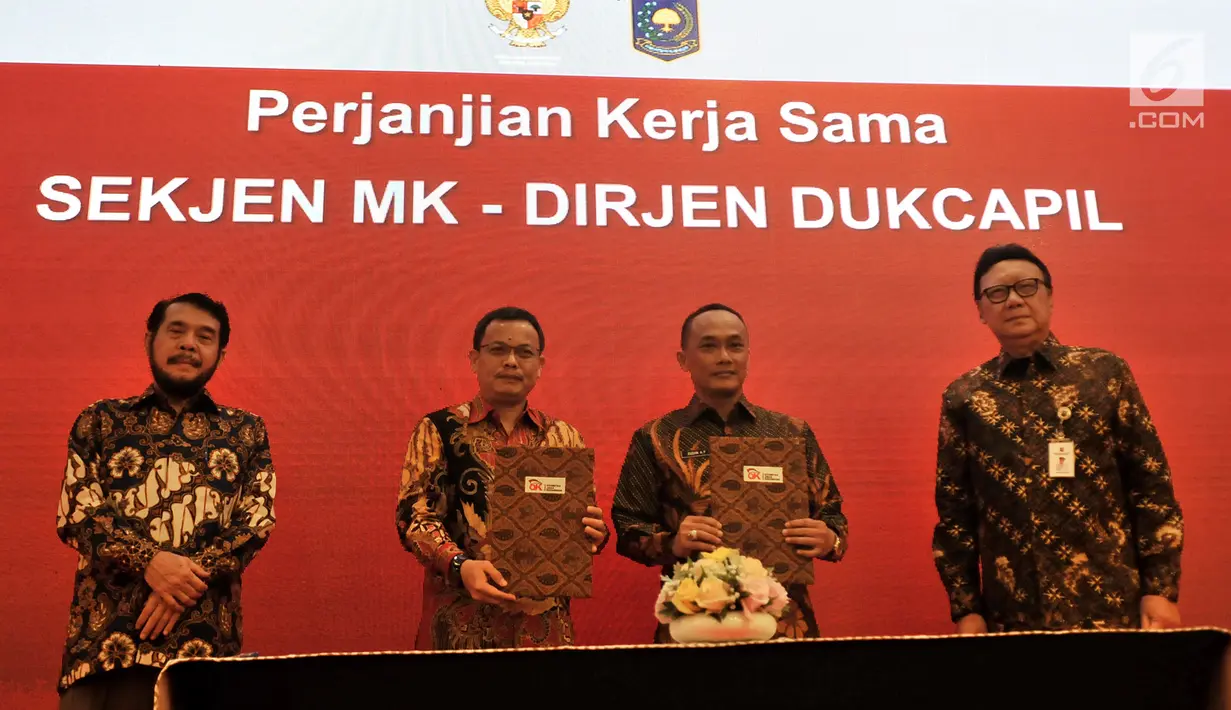 Mendagri Tjahjo Kumolo (kanan) bersama Ketua Dewan Komisioner OJK Wimboh Santoso (kiri) mendampingi Dirjen Dukcapil dan Dirjen Bina Keuangan Daerah melakukan penandatanganan Nota Kesepahaman di Jakarta, Selasa (19/2). (Merdeka.com/Iqbal Nugroho)
