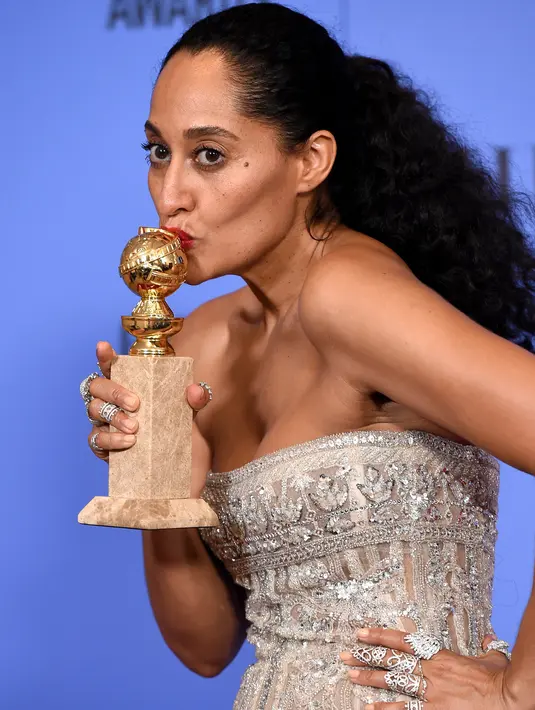 Aktris Tracee Ellis Ross mencium trofi yang berhasil dimenangkannya pada ajang Golden Globes di California, Minggu (8/1). Tracee Ellis Ross berhasil memenangkan kategori itu melalui perannya dalam serial televisi 'Black-ish'. (Jordan Strauss/Invision/AP)