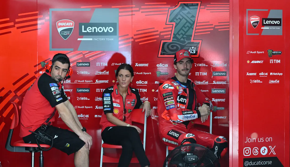 Pebalap Lenovo Ducati Francesco Bagnaia (kanan) duduk bersama anggota timnya sembari menunggu tes pramusim MotoGP 2024 di Sirkuit Internasional Sepang, Sepang, Malaysia, Selasa (06/02/2024).  (AFP/Mohd Rasfan)