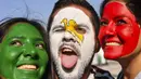 Para suporter melukis wajahnya dengan warna bendera Meksiko saat berada di Yekaterinburg, Rabu (27/6/2018). (AFP/Hector Retamal)