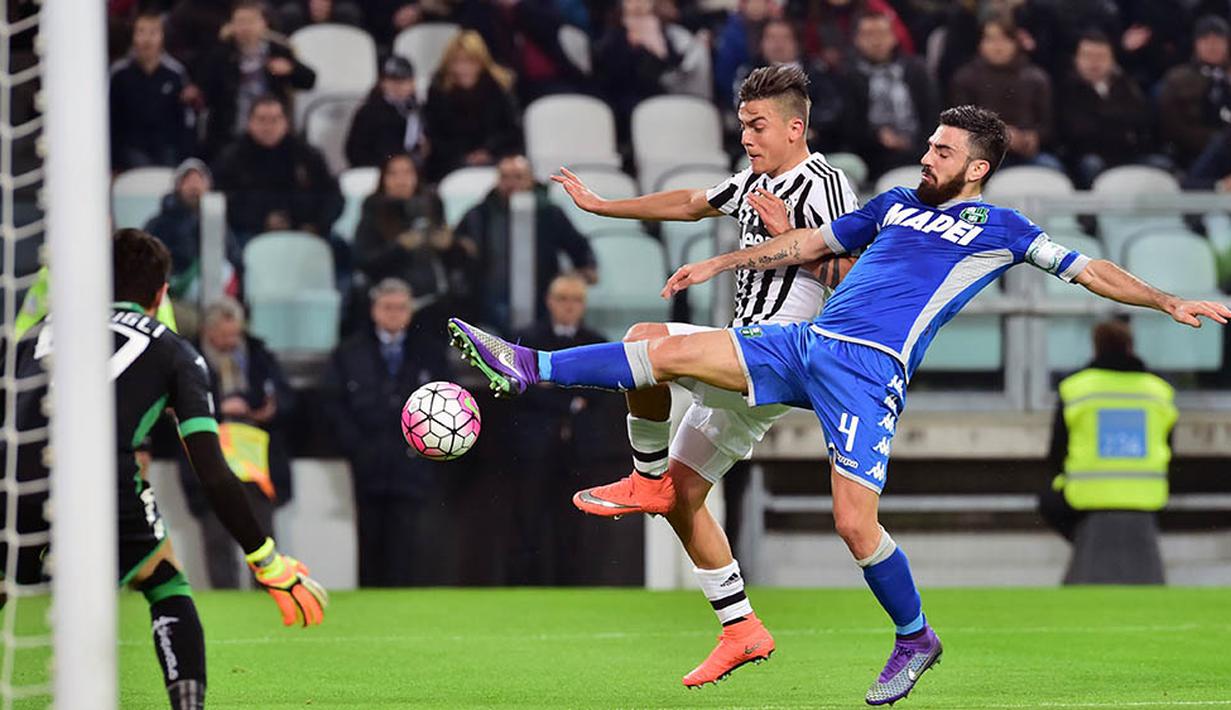 Striker Juventus, Paulo Dybala , berebut bola dengan gelandang Sassuolo, Francesco Magnelli. Gol kemenangan Juve yang dicetak Paulo Dybala tercipta pada menit ke-39 melalui umpan Juan Cuadrado. (AFP/Giuseppe Cacace)