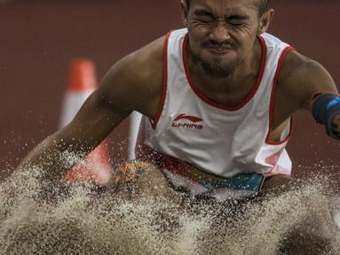 Atlet lompat jauh Indonesia, Settiyo Budi Hartanto, melakukan lompatan saat tampil pada cabang atletik nomor lompat jauh  T 45/46/47 Asian Para Games di SUGBK, Jakarta, Senin (8/10/2018). (Bola.com/Vitalis Yogi Trisna)