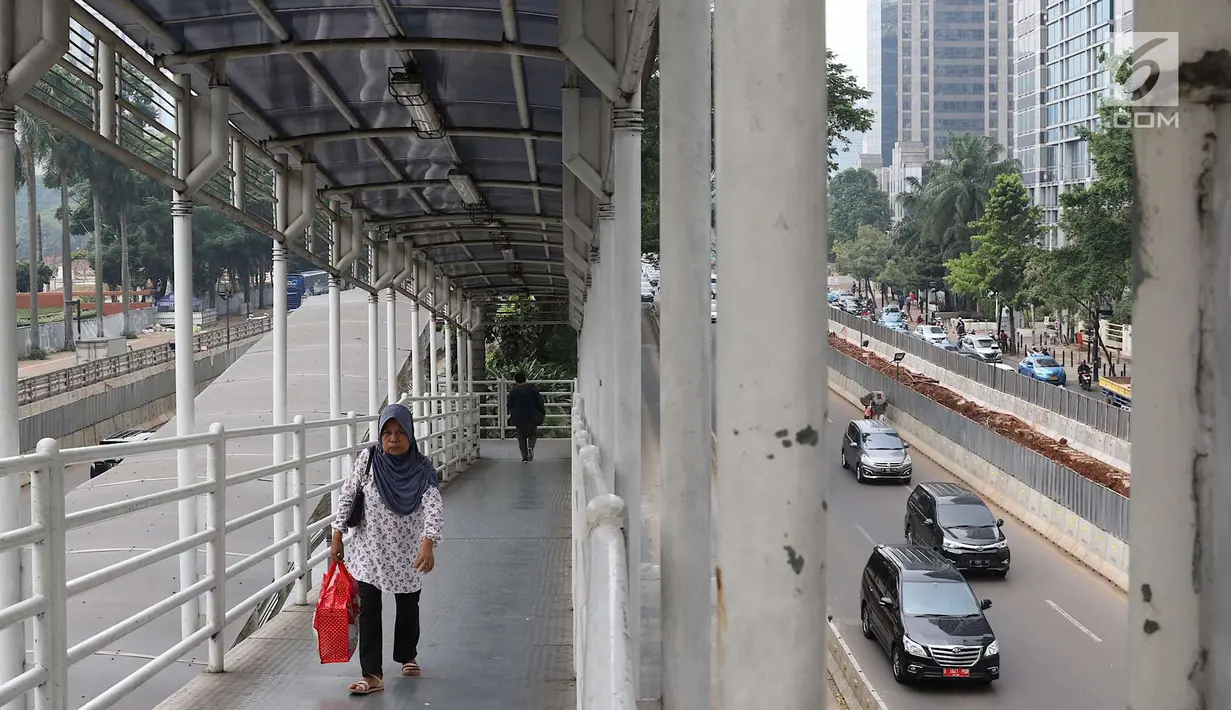 Pejalan kaki melintasi JPO Gelora Bung Karno di Jakarta, Kamis (3/5). Prioritas utama yang akan direnovasi terlebih dahulu, yaitu JPO Polda Metro Jaya, JPO Ratu Plaza, dan JPO Gelora Bung Karno. (Liputan6.com/Immanuel Antonius)