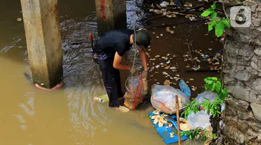 Warga kerja bakti membersihkan sampah yang terbawa aliran Kali Baru di bawah Jembatan Merah, Jalan Pitara Raya, Depok, Jawa Barat, Rabu (19/2/2020). Pascahujan deras yang terjadi sehari sebelumnya, sampah dari arah Bogor terbawa aliran Kali Baru hingga ke Depok. (merdeka.com/Magang/Muhammad Fayyadh)