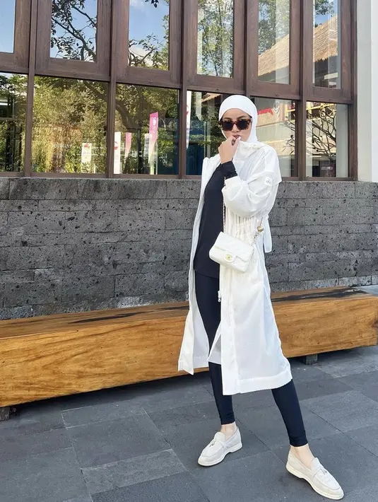 Olla mengenakan outer putih panjang serasi dengan kerudungnya, dipadukan inner manset lengan panjang dan celana panjang hitam. [Instagram/@ollaramlan]