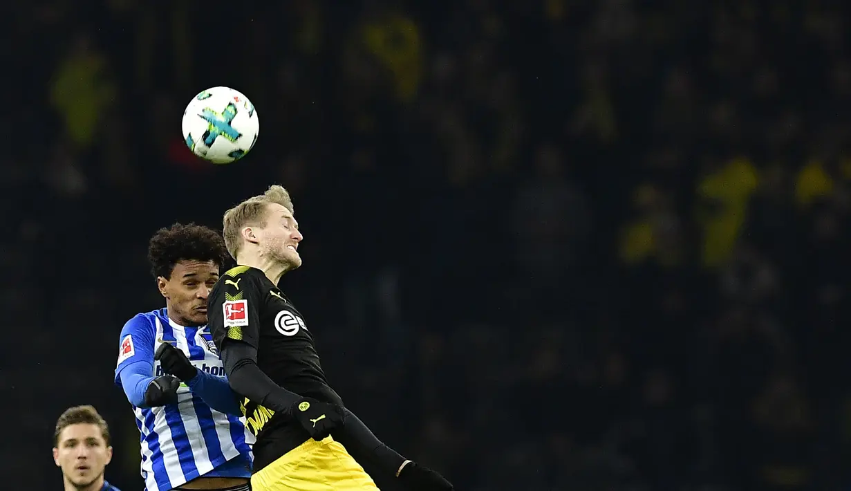 Gelandang Hertha Berlin Valentino Lazaro berebut bola dengan pemain Borussia Dortmund, Andre Schuerrle dalam lanjutan Bundesliga di Olympiastadion Berlin, Sabtu (20/1). Dortmund hanya mampu bermain imbang 1-1 melawan Hertha Berlin. (Tobias SCHWARZ/AFP)