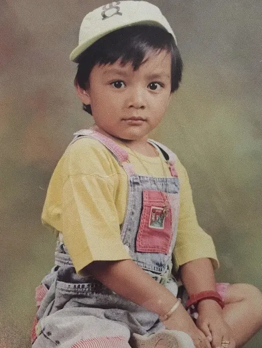 Sejak kecil ia sudah tampak bergaya dengan pakaian overallnya. Dan topi cap putihnya.