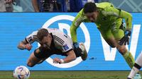 Pemain Timnas Jerman, David Raum (kiri) terjatuh di dalam kotak penalti usai dilanggar kiper Timnas Jepang, Shuichi Gonda dalam laga matchday pertama Grup E Piala Dunia 2022 di Khalifa International Stadium, Doha, Qatar, Rabu (23/11/2022) malam WIB. (AP/Eugene Hoshiko)