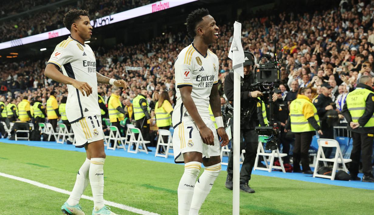 Pemain Real Madrid, Vinicius Junior dan Rodrygo melakukan selebrasi setelah mencetak gol ke gawang Valencia pada laga Liga Spanyol di Stadion Santiago Bernabeu, Sabtu (11/11/2023). Real Madrid menang dengan skor 5-1. (AFP/Thomas Coex)