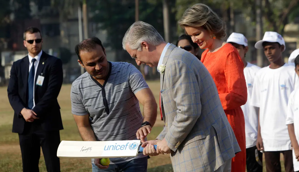 Pemain kriket India Virendar Shehwag mengajarkan Raja Philippe dan Ratu Belgia Mathilde bermain kriket di Oval Maidan di Mumbai, India, Jumat, (10/11). (AP Photo / Rajanish Kakade)