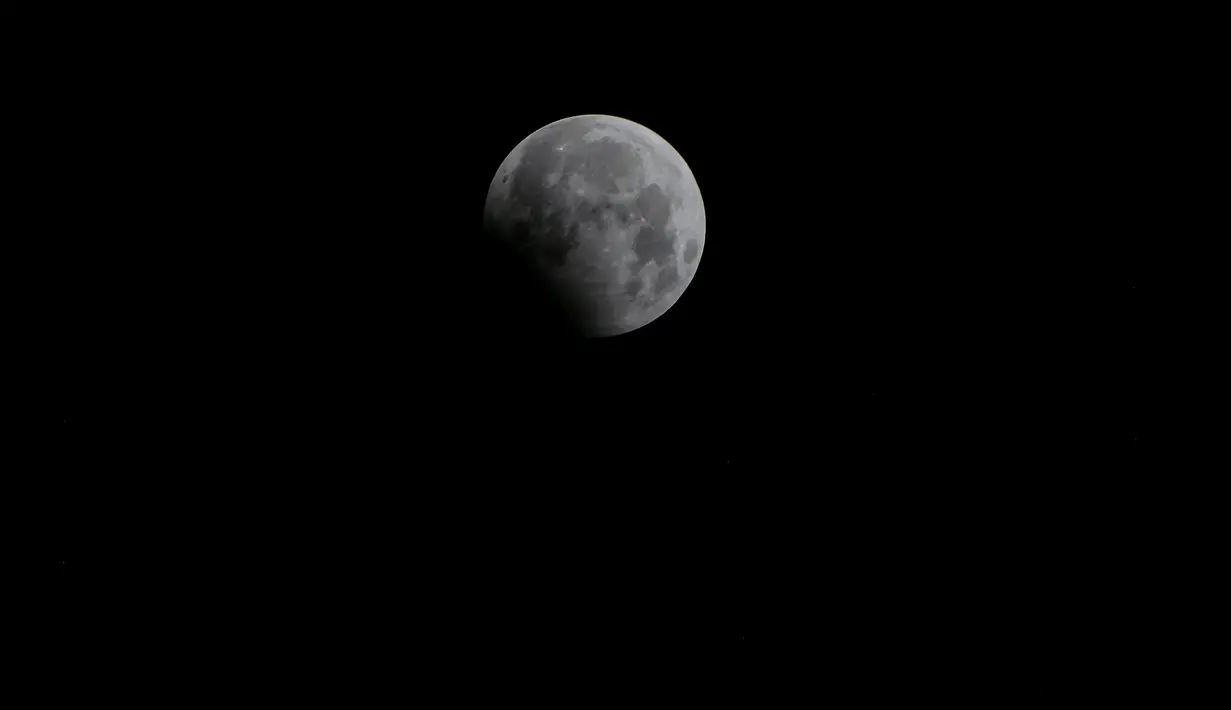 Bulan purnama saat puncak gerhana bulan penumbra terlihat di langit Jakarta, Indonesia, Senin (7/8).Gerhana bulan penumbra adalah gerhana samar karena bulan purnama hanya terkena bayangan sekunder. (BAY ISMOYO / AFP)