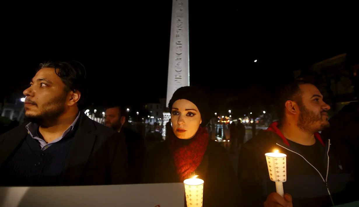 Warga Suriah yang tinggal di Turki memegang lilin dan bunga di lokasi bom bunuh diri di Sultanahmet Square, Istanbul, Rabu (13/1). Bunga dan lilin tersebut wujud belasungkawa untuk korban ledakan di Turki. (REUTERS/Osman Orsal)