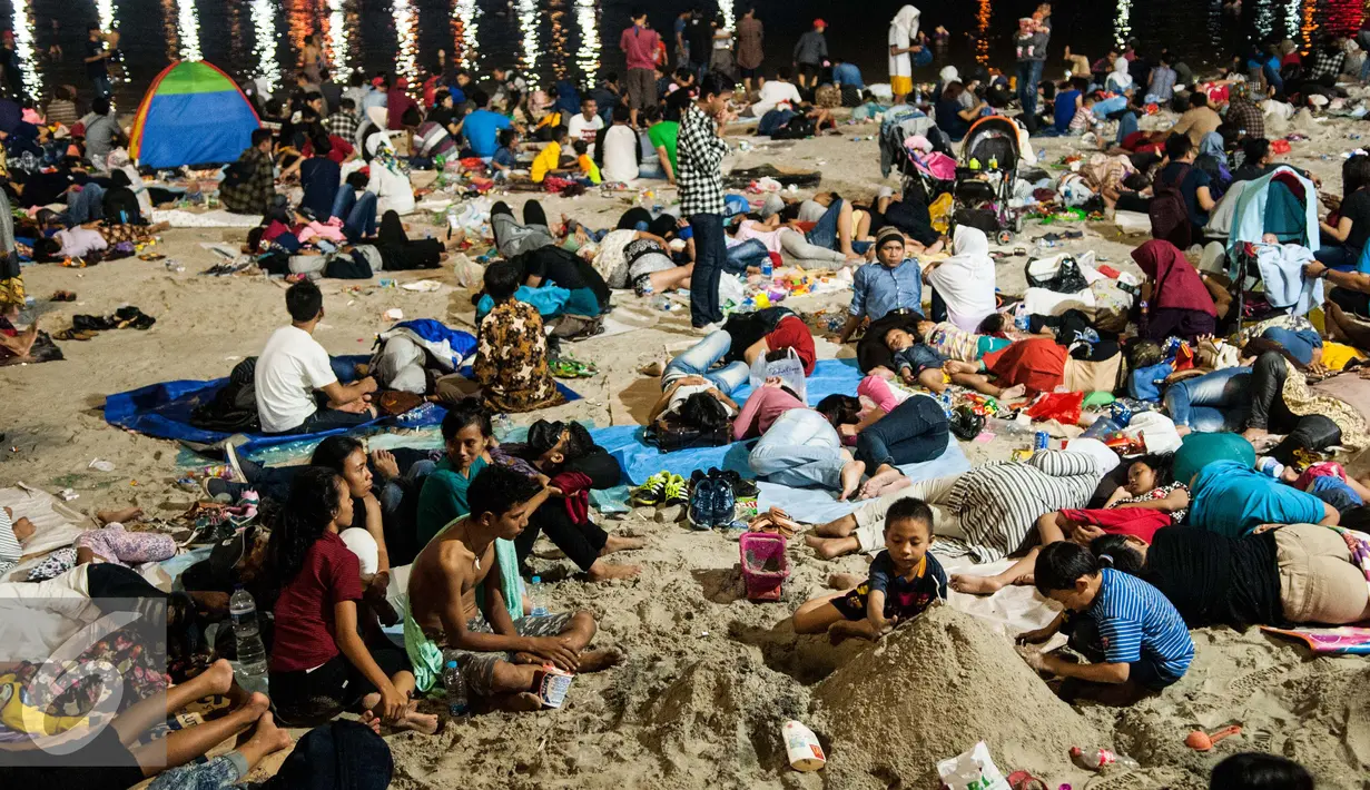 Dua orang anak bermain pasir usai menyaksikan atraksi kembang api pergantian tahun di Pantai Lagoon, Ancol, Jakarta, Minggu (1/1). (Liputan6.com/Gempur M. Surya)