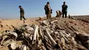 Tulang belulang terlihat di sebuah kuburan massal yang diduga lokasi makam anggota Yazidi Irak di pinggiran kota Sinjar, 30 November 2015. Pasukan Kurdi menemukan kuburan ini usai berhasil merebut kembali kota Irak dari militan ISIS. (Reuters/Ari Jalal)