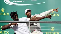 Lewis Hamilton bergaya dengan pelari Usain Bolt usai juara di GP AS (CLIVE MASON / GETTY IMAGES NORTH AMERICA / AFP)