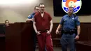 Terdakwa penembak di bioskop Colorado, James Holmes dikawal petugas usai mengikuti sidang di Centennial, Colorado, Rabu (26/8/2015). James dijatuhi hukuman penjara seumur hidup tanpa pembebasan bersyarat atas pembunuhan 12 orang.(REUTERS/RJ Sangosti/Pool)