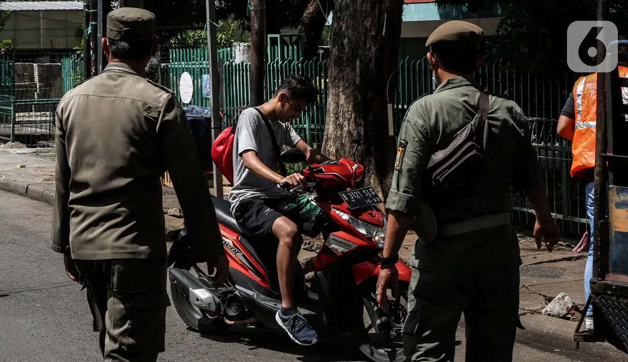 Petugas menghentikan pengendara motor saat Razia Protokol Kesehatan di kawasan Kebayoran Lama, Jakarta, Selasa (19/10/2021). Razia PPKM Level 3 kerap dilakukan demi memutus rantai penyebaran covid 19, dengan sanksi denda Rp 100.000 dan sanksi sosial seperti menyapu jalan. (Liputan6.com/Johan Tallo)