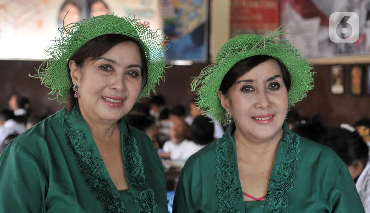 Sri Irianingsih (kanan) dan Sri Rossyati (kiri) berpose saat mengajar siswa Sekolah Darurat Kartini di kawasan Lodan, Jakarta Utara, Senin (25/11/2019). Sri Rossyati dan Sri Irianingsih berharap mampu memberikan pendidikan berkualitas agar anak-anak menjadi lebih baik. (merdeka.com/Iqbal Nugroho)