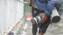 Jurnalis melindungi dirinya saat meliput demontrasi yang memanas di depan gedung Dewan Perwakilan Rakyat (DPR), Senayan, Jakarta, Selasa (24/9/2019). Polisi menembakkan gas air mata dan meriam air untuk membubarkan massa aksi yang menolak RKUHP dan RUU kontroversial lain. (merdeka.com/Arie Basuki)