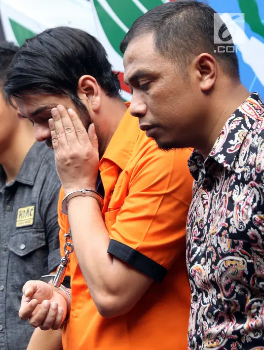 Pesinetron Rio Reifan diapit petugas Direktorat Reserse Narkoba Polda Metro Jaya saat rilis, Jakarta, Jumat (16/8/2019). Rio Reifan ditangkap polisi di sebuah SPBU di Cibubur setelah membeli paket sabu seharga Rp 350 ribu. (Liputan6.com/Helmi Fithriansyah)