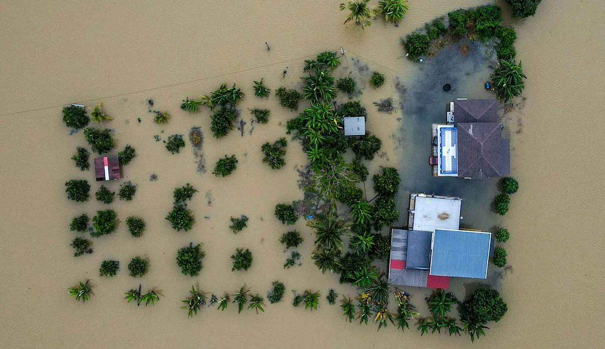 Banjir yang menggenangi sebagian wilayah Malaysia tidak hanya dipicu oleh hujan lebat dan angin kencang akibat siklon tropis yang berkembang selama musim hujan timur laut. Tampak foto udara menunjukkan sebuah rumah yang terendam banjir di Kangar, negara bagian Perlis, Malaysia utara, pada Kamis 27 November 2025. (Mohd RASFAN/AFP)