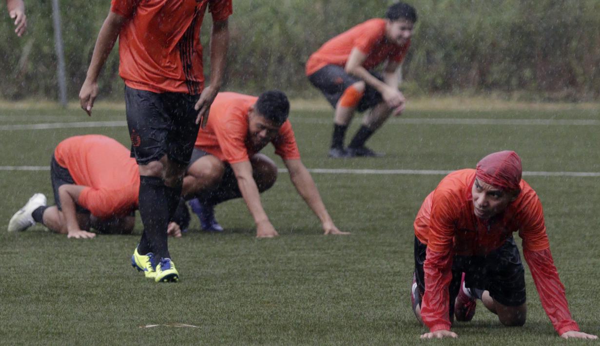 Pemain Persija Jakarta, Novri Setiawan, tampak tiarap saat ada petir di Lapangan NYTC, Sawangan, Depok, Kamis (16/1/2020). Hujan deras beserta petir membuat latihan Persija Jakarta kali ini hanya berlangsung sekitar 25 menit. (Bola.com/M Iqbal Ichsan)