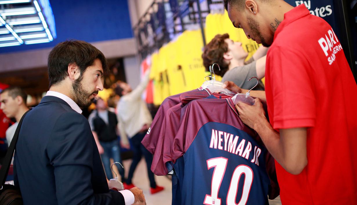 Fans memilih jersey pemain baru Paris Saint Germain, Neymar Jr, di toko merchandise di Paris, Jumat (4/8/2017). Setelah resmi bergabung dengan Paris Saint Germain, jersey Neymar Jr langsung diburu suporter klub Ibu kota. (AFP/Benjamin Cremel)