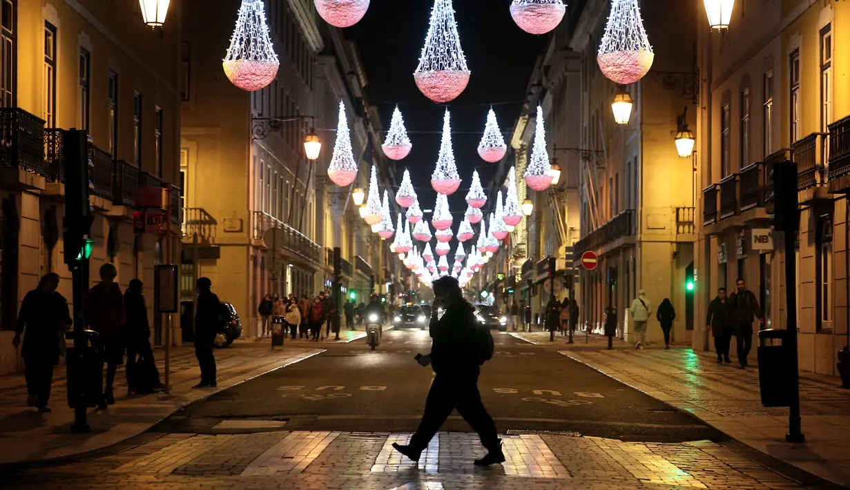 Sejumlah warga yang mengenakan masker berjalan di bawah lampu-lampu Natal dan Tahun Baru pada masa pandemi COVID-19 di Kota Lisbon, Portugal, 17 Desember 2020. Portugal yang memiliki populasi lebih dari 10 juta telah mencatat sebanyak 362.616 kasus COVID-19 dan 5.902 kematian. (Xinhua/Pedro Fiuza)