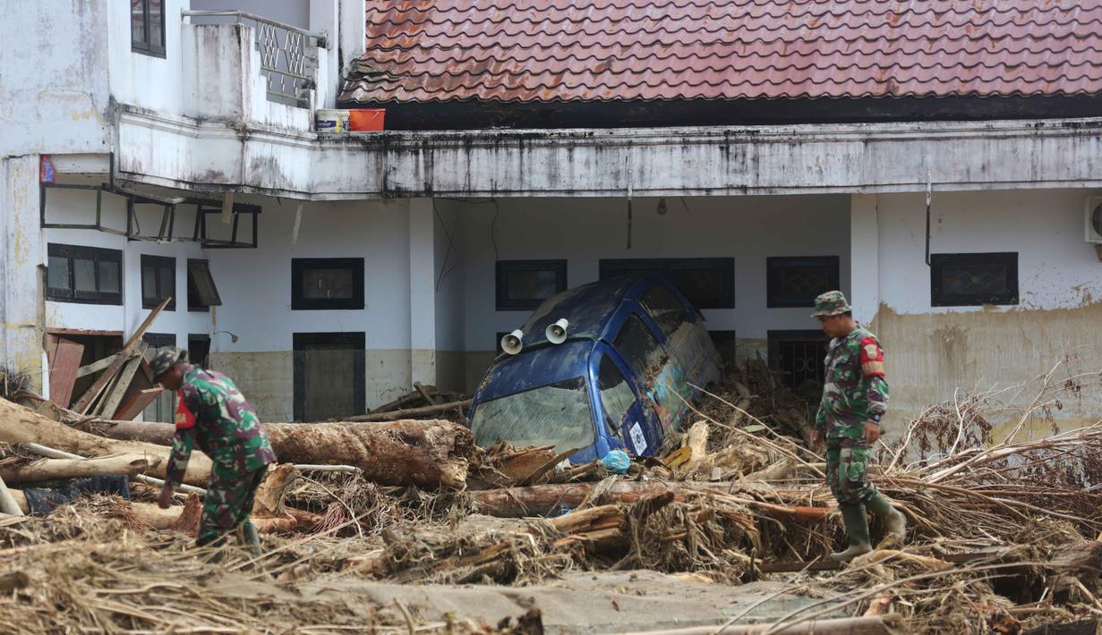 Tumpukan-tumpukan kayu gelondongan ini merupakan material yang terbawa arus banjir bandang yang terjadi Selasa (25/11/2025) lalu. Tampak dalam foto, personel Tentara Nasional Indonesia (TNI) mencari korban banjir di Batang Toru, Sumatra Utara, Selasa 2 Desember 2025. (AP Photo/Binsar Bakkara)