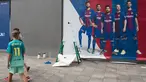Seorang anak mengenakan jersey Neymar melewati sebuah poster baru yang dipasang di luar Stadion Camp Nou di Barcelona (2/8). Sebelumnya, poster tersebut menampilkan pemain depan Barcelona Neymar dari Brasil. (AFP Photo/Josep Lago)
