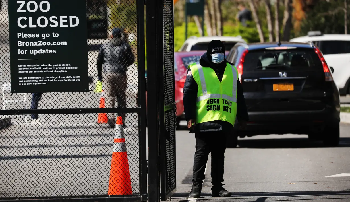 Seorang penjaga berdiri di pintu masuk ke Kebun Binatang Bronx di New York City, Amerika Serikat, Senin (6/4/2020). Tertularnya seekor harimau di Kebun Binatang Bronx oleh virus corona COVID-19 dianggap sebagai kasus pertama yang menjangkit harimau. (Spencer Platt/Getty Images/AFP)