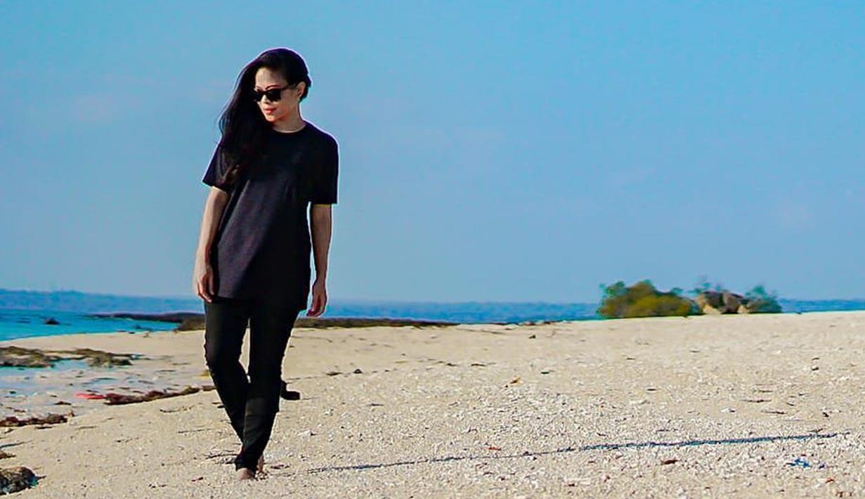 Saat berlibur di pantai, Kikan juga tetap mengenakan busana serba hitam. Ia juga mengenakan kacamata berwarna hitam sebagai pelengkap. (Liputan6.com/IG/@kikankikan)