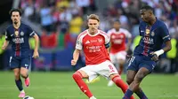 Bek Paris Saint-Germain asal Ekuador, Willian Pacho (#51), mengoper bola di depan gelandang Arsenal FC asal Norwegia, Martin Odegaard (#8), dalam pertandingan final Liga Champions antara PSG dan Arsenal FC di Puskas Arena, Budapest, pada 30 Mei 2026. (Foto: NICOLAS TUCAT / AFP.)