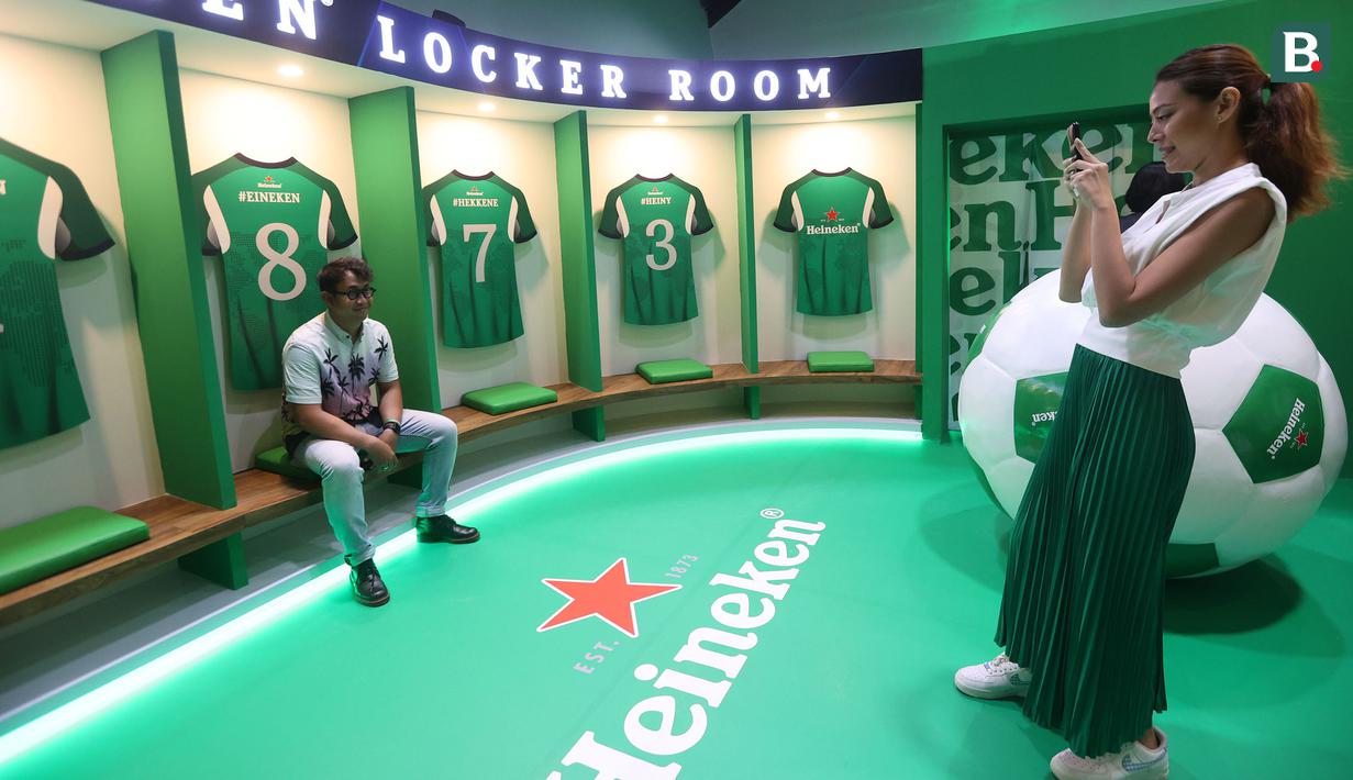Pengunjung berfoto di ruang ganti yang tersedia dalam acara bertajuk Meet The UEFA Champion League Trophy and Legends di MGP Space SCBD, Jakarta, Sabtu (27/4/2024). (Bola.com/M iqbal Ichsan)