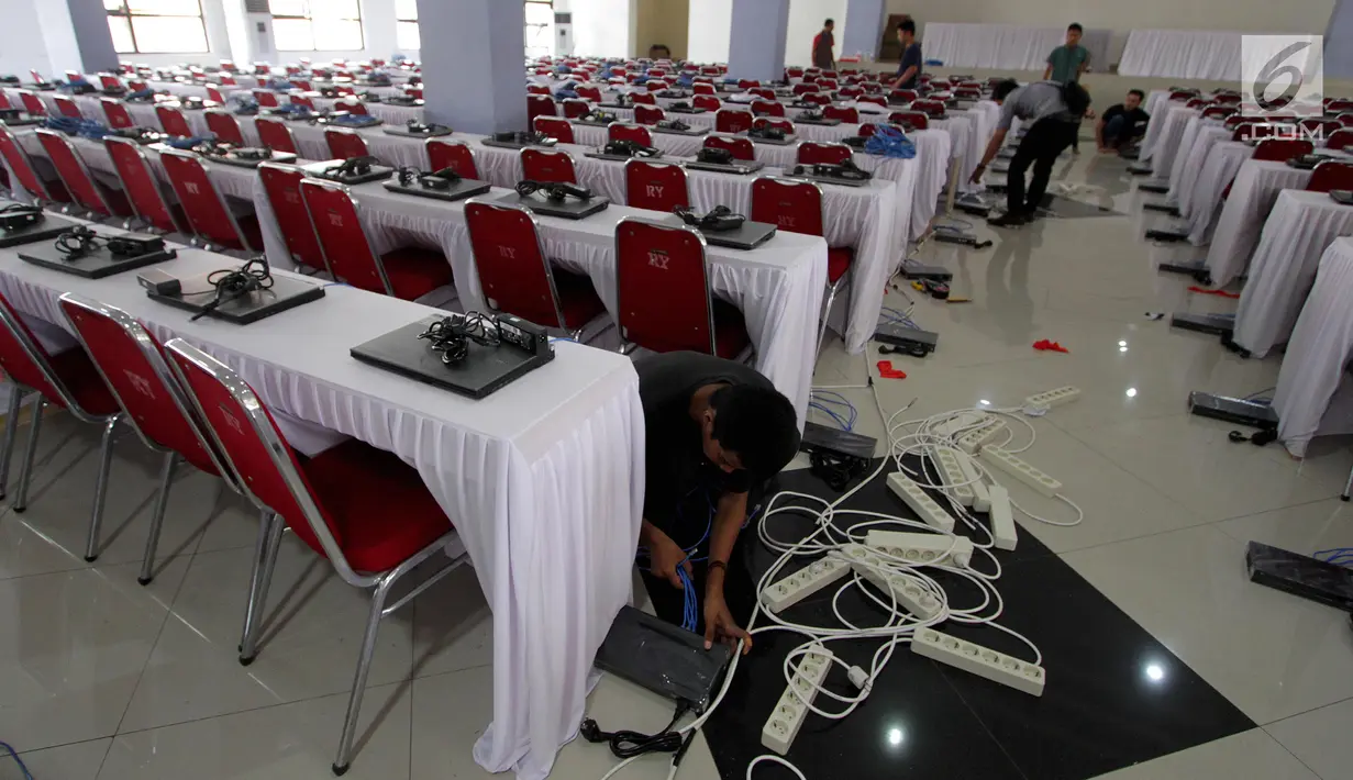 Teknisi menginstal laptop untuk tes calon pegawai negeri sipil (CPNS) di GOR Kelapa Gading, Jakarta Utara, Jumat (26/10). Tempat ini akan menjadi lokasi tes CPNS yang akan dilangsungkan pada Sabtu, 26 Oktober 2018. (Liputan6.com/JohanTallo)