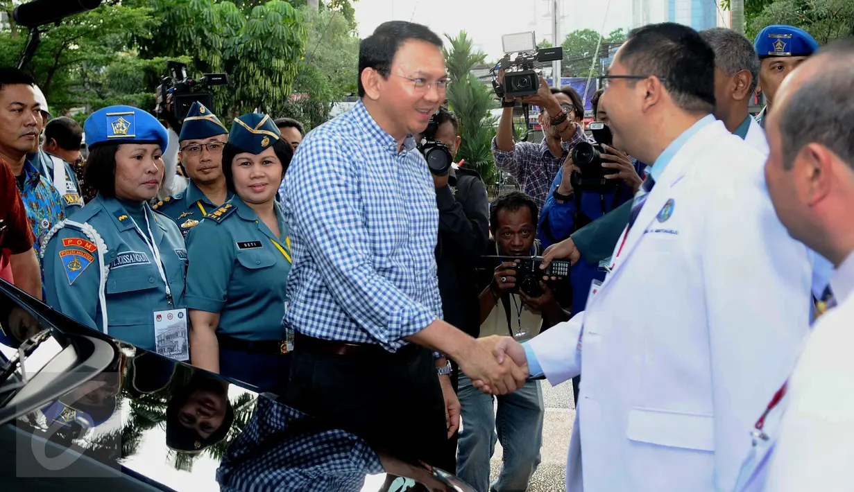 Cagub DKI Jakarta 2017 Basuki Tjahaja Purnama berjabat tangan dengan tim dokter saat akan menjalani tes kesehatan di RSAL Dr. Mintoharjo, Jakarta, Sabtu (24/9). Ahok tiba dengan mengenakan kemeja kotak-kotak berwarna biru. (Liputan6.com/Gempur M Surya). 