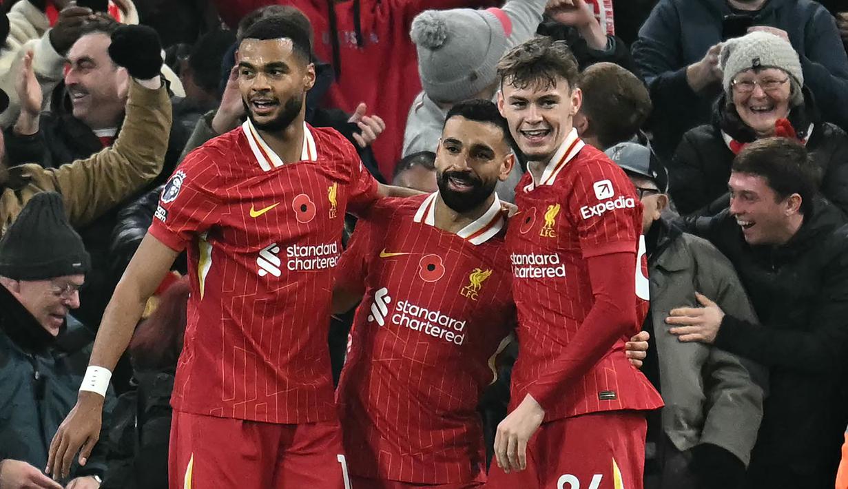 Pemain Liverpool, Mohamed Salah melakukan selebrasi setelah mencetak gol bersama Cody Gakpo (kiri) dan Conor Bradley (kanan) pada laga lanjutan Liga Inggris 2024/2025 melawan Aston Villa yang berlangsung di Anfield, Liverpool, Inggris, Minggu (10/11/2024) WIB. (AFP/Paul Ellis)