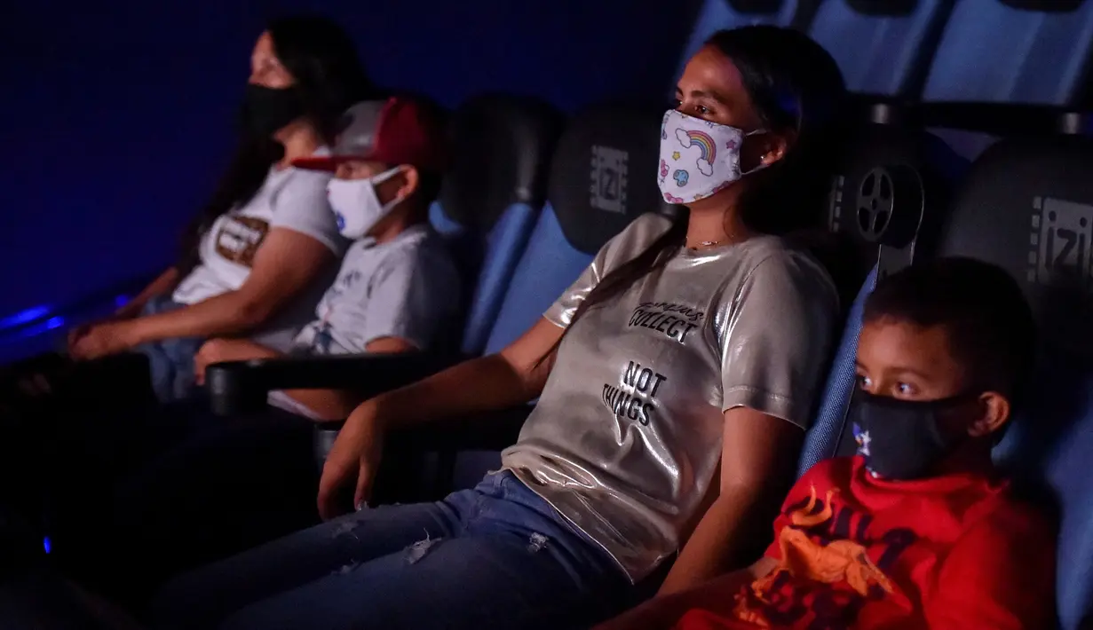 Orang-orang menonton film di bioskop yang dibuka kembali menyusul pelonggaran langkah-langkah yang diberlakukan oleh pemerintah Kolombia untuk menghentikan penyebaran Covid-19, di Cali, Kolombia pada Jumat (2/10/2020). (Photo by Luis ROBAYO / AFP)