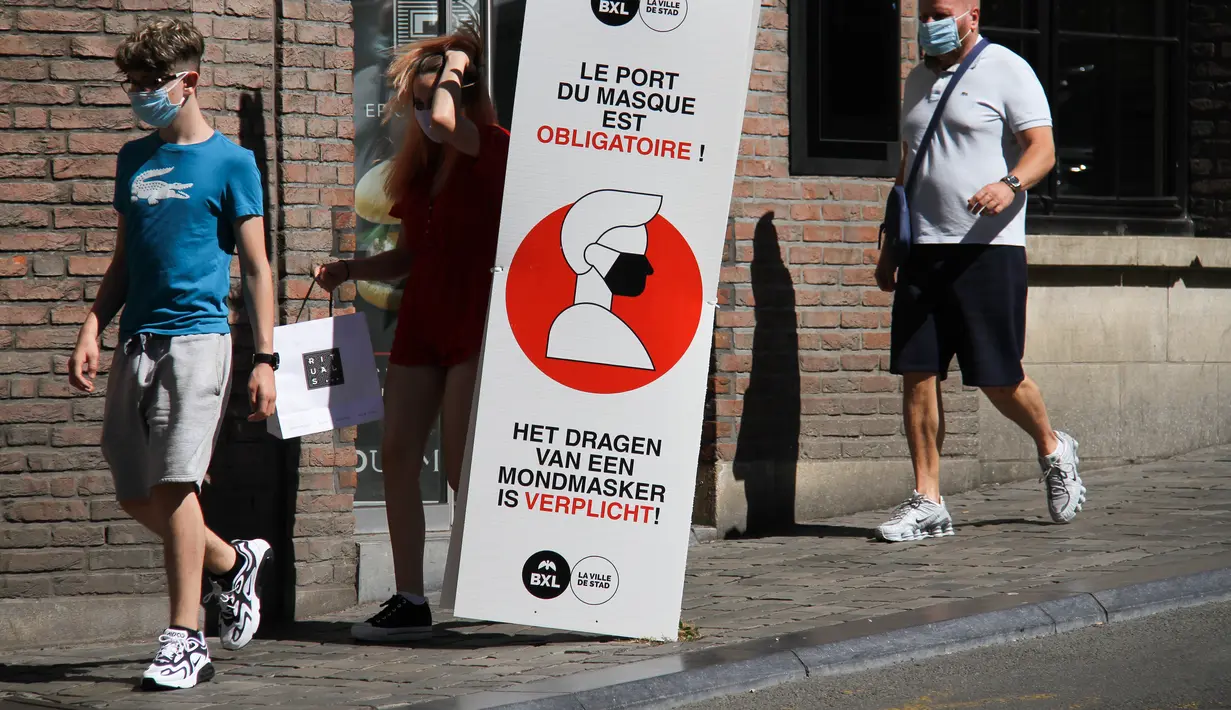 Sejumlah orang berjalan melewati spanduk informasi yang mengingatkan masyarakat untuk mengenakan masker di Brussel, Belgia (5/8/2020). Kota Brussel memperluas aturan wajib pakai masker di wilayahnya hingga termasuk di jalan-jalan yang ramai dan zona pejalan kaki. (Xinhua/Zheng Huansong)