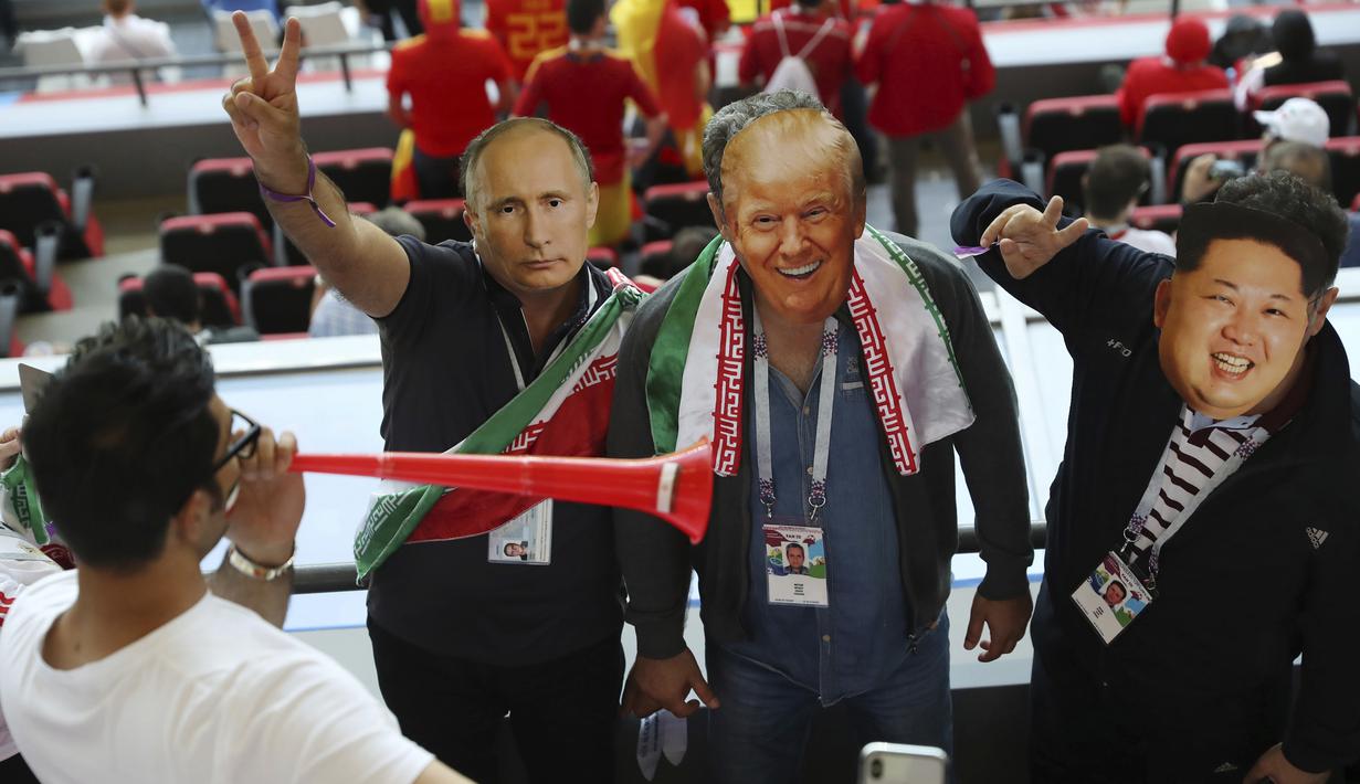 Suporter Iran memakai topeng wajah dari Donald Trump, Vladimir Putin dan Kim Jong-un saat menonton laga grup B Piala Dunia melawan Spanyol di Kazan Arena, Kazan, Rabu (20/6/2018). Iran kalah 0-1 dari Spanyol. (AP/Eugene Hoshiko)