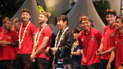 Ekspresi bahagia pelatih dan pemain Timnas Indonesia saat memakai blangkon khas Jawa Timur disela-sela kegiatan menyapa masyarakat Surabaya dan sekitarnya yang berlangsung di Balai Kota Surabaya, Minggu (11/6/2023). (Bola.com/Wahyu Pratama)