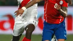 Gelandang Peru, Luis Advincula berusaha melewati gelandang Chili, Arturo Vidal saat semifinal Copa Amerika 2015 di National Stadium, Santiago, Chili, (29/6/2015). Chili melaju ke final usai mengalahkan Peru 2-1. (REUTERS/Henry Romero)