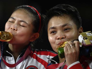 Atlet Badminton Ganda Putri Indonesia Apriyani Rahayu (kanan) dan Greysia Polii berpose dengan medali emas Olimpiade Tokyo 2020 di Musashino Forest Sports Plaza, Tokyo, Senin (2/8/2021). (Foto: AFP/Alexander Nemenov)