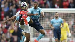 Penyerang Arsenal, Alex Iwobi, berebut bola dengan penyerang Swansea, Wayne Routledge, pada laga Premier League di Stadion Emirates, London, Sabtu (15/10/2016). Arsenal menang 3-2 atas Swansea. (Reuters/Hannah McKay)
